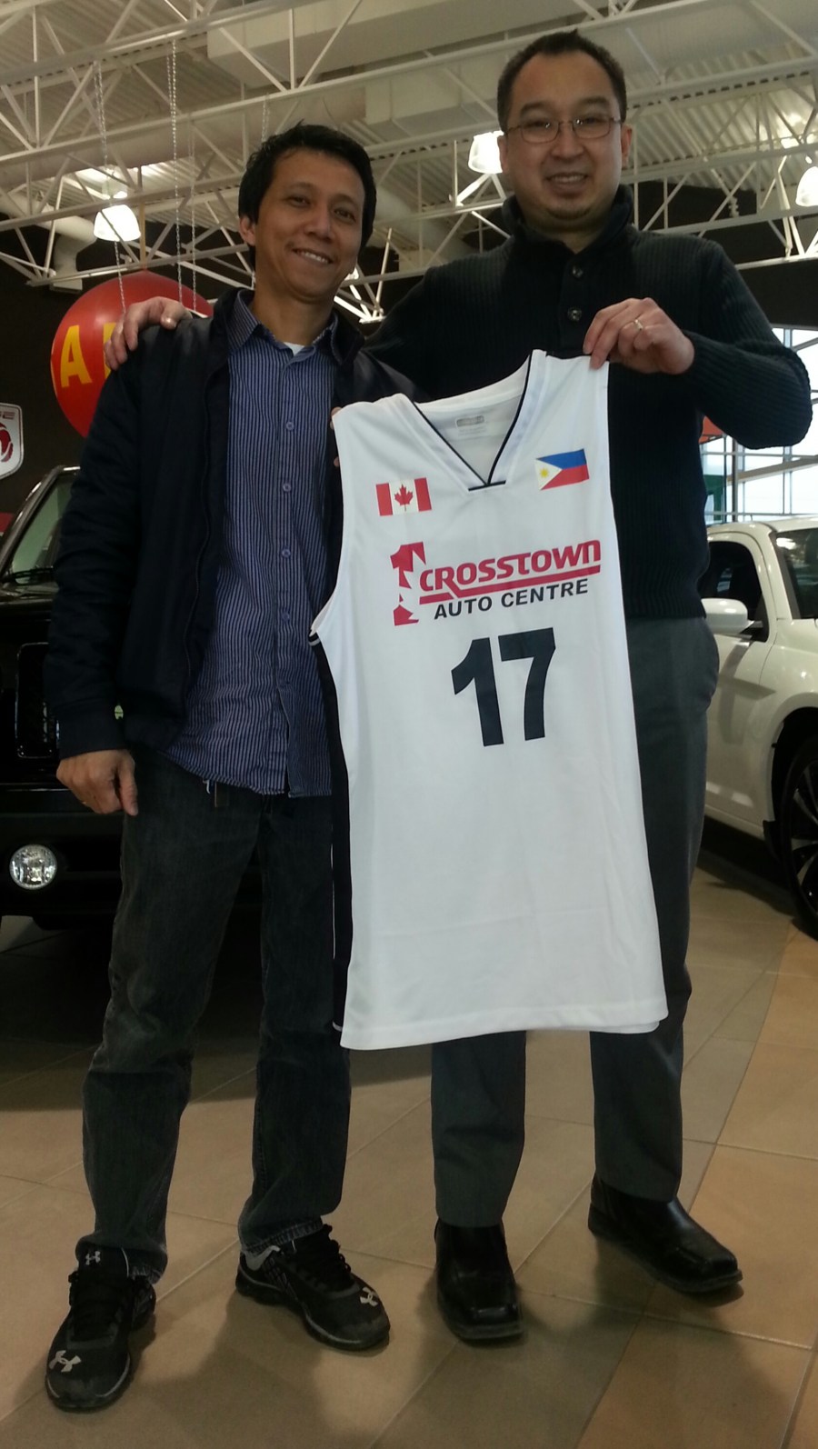 Zaldy Dimaano, president of the Sherwood Park Basketball Association (SPBA), proudly present one of the uniforms provided by Crosstown Auto Centre for their upcoming league. With him is Chester Tiongson, representing Crosstown Auto Centre.(Photo by Moses Billacura/p.e.n.) 