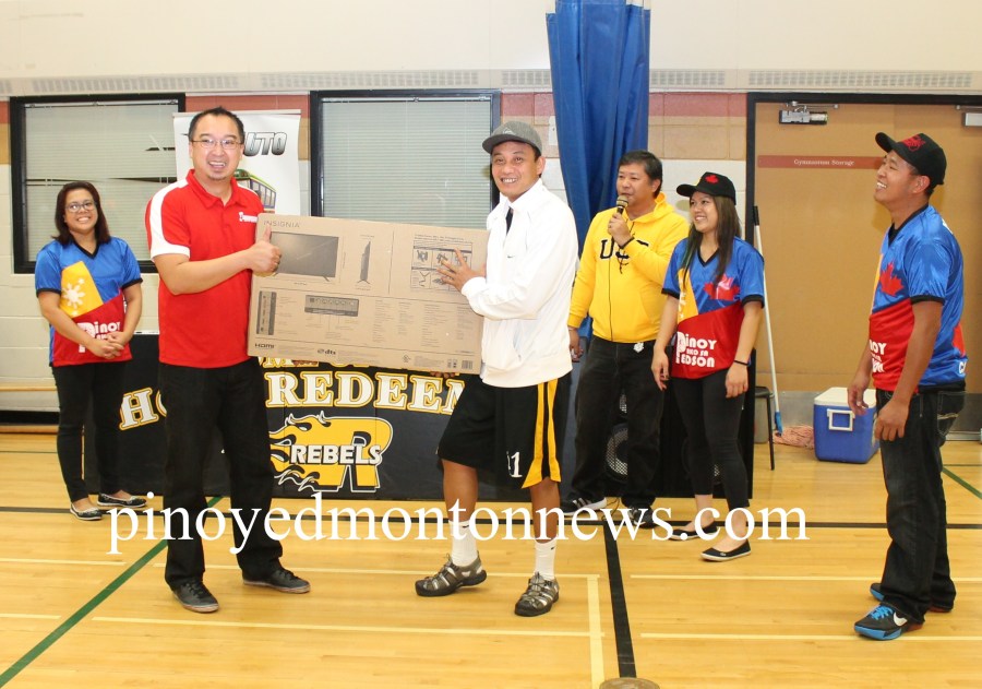 Antonio Nuyda of Grande Prairie team happily receives the raffle prize from Crosstown Auto's Chester Tiongson. In the photo are organizers Aileen Gabito, Joey Manalang, Rande Cagalitan and Rodel Gravides.(Photo by Moses Billacura/pinoy edmonton news)